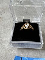 Ring in clear plastic display box, top view