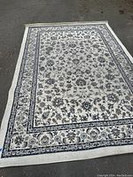 Full view of the large area rug showing the central floral pattern and border detailing.