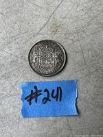Reverse side of vintage 1941 Canadian 50 cent silver coin showing Canadian coat of arms and denomination.