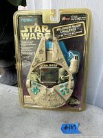 Front view of sealed Star Wars Tiger Electronics Millennium Falcon handheld game still in original blister packaging.