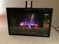 Front view of Spectrafire electric fireplace showing multi-color flame effect and realistic logs.