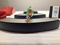 Front view of three glass mirrored stands arranged in a Christmas tree shape with small ornament figures on top.