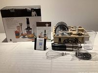 Full lot display showing immersion blender main unit, whisk attachment, chopping bowl, measuring cup, instruction manual and original box.