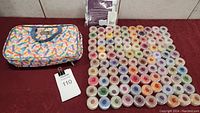 Photo showing 100 Scentsy wax scent sample containers arranged in rows next to the colorful carrying case and some packaging material behind them.
