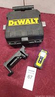 DeWalt branded hard carrying case, laser distance measurer tool, and mounting bracket displayed on fabric surface.