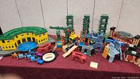 Overview of assorted Thomas the Train toy structures including a green turntable, bridges, and vertical components on a table
