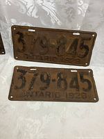 Matched pair of original 1928 Ontario vehicle license plates with number 379-845, showing wear and paint loss.