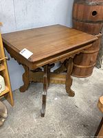 Front and side view of the antique parlour table showing solid wood top and ornate base structure.