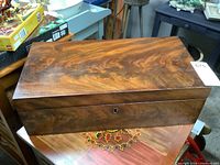 Top and front view of the antique mahogany portable writing box, showing keyhole and wood grain.