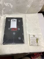 Photo showing sealed black Upper Deck The Jordan Experience package and Michael Jordan gold foil card packet side by side on white fabric.