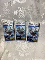 Three boxes of small Yamagi warship models by Takara, standing side by side on fabric backdrop, showing front packaging with ship image and Japanese text.
