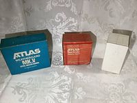 Boxes of three radios: blue Atlas Weathergard MK.V tire radio box, red Atlas Red Brute Battery radio box, plain white Esso radio box.