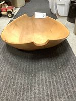 Front and side view of the oval wooden bowl showing the carved notch and natural wood finish