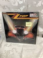 Front cover of ZZ Top Eliminator LP showing classic car artwork and band name, with price sticker attached