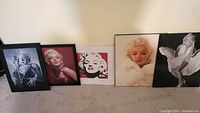 Full view of five Marilyn Monroe pictures, arranged side by side showing size and variety including framed and unframed prints.