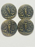 Four antique brass buttons shown from the front with hunting scene relief