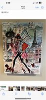 Photo of colorful Paris-themed artwork featuring a woman, dog, Eiffel Tower and various Paris landmarks.