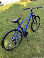 Side-angle view from rear showing frame, drivetrain, rear wheel and seat