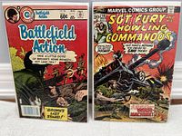 Photo showing front covers of two comic books: Battlefield Action No. 76 (August 1982) and Sgt Fury and His Howling Commandos No. 135 (March 10, 1974). Both comics appear to be in protective plastic bags with backing boards.