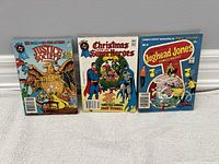 Photo showing three vintage comic books side by side: Justice Society of America, Christmas with The Super Heroes, and Jughead Jones Comic Digest.