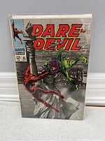 Front cover photo of Daredevil comic book issue #46 with Statue of Liberty background and Daredevil character in red fighting a green villain, item bagged and boarded.