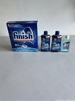 Photo showing four dishwasher detergent and rinse aid products: a box of Finish Powerball tablets, two bottles of Finish Gel detergent, and one bottle of Jet-Dry rinse aid.