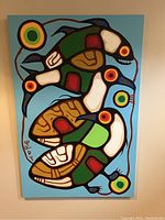 Front view of canvas showing stylized animal shapes in green, white, brown and red on a blue background with circular motifs