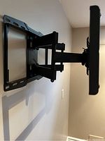 Side view of the black TV wall mount bracket showing the articulated arm for extending and tilting the TV.