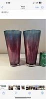 Photo showing two tall ribbed glass vases with a purple to teal gradient color next to a soda can for size reference.