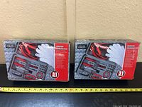 Two unopened 31-piece roadside emergency kits side by side showing front packaging with included tools visible