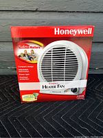 Front side of the original box showing Honeywell compact heater fan branding and product image.