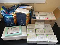 Full view of all items including Desert Flower Essence Kit box, multiple white boxes, and two reusable bags holding some boxes.