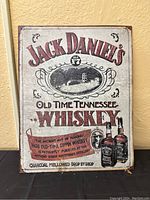 Full view of the metal poster showing Jack Daniel's Old No. 7 Tennessee Whiskey advertisement with wear and age marks.