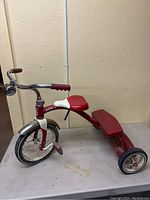 Side view of the old Radio Flyer tricycle showing the overall design, condition and seat.