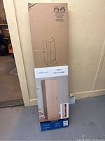 Full unopened boxed pantry cabinet from Mainstays showing packaging and product layout.