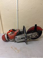 Left-side view showing engine housing, starter handle and fuel tank