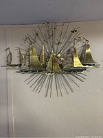 Front view of full metal wall sculpture showing sailboat silhouettes against starburst backdrop