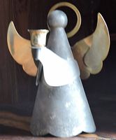 Metal angel candleholder with halo and wings holding a cup for candle