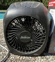 Front view photo of black Sunbeam indoor space heater with fan and buttons.