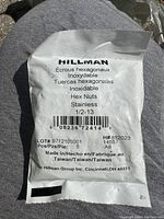 Hillman branded sealed packet of stainless steel hex nuts, labeled 1/2-13