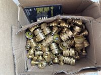 Box of multiple brass quick connect female couplings showing the quantity and condition.