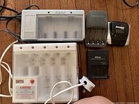 Photo showing multiple battery chargers including Energizer, Duracell, Nikon MH-24 charger and other battery chargers for AA and AAA batteries