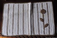 White and brown crochet placemat with flower design laid flat on table