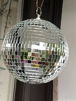 Front perspective of the disco ball showing square mirror tiles and its reflective, shiny surface.