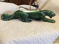 Side view of the green ceramic panther lamp showing full length and curled tail detail.