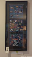 Full view of large framed embroidered textile art containing three panels with agricultural and wildlife scenes