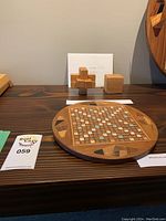 Miniature wood Scrabble board and two wooden puzzles displayed on a table.