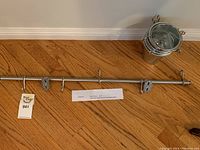 Metal rail laid on wooden surface showing length and mounting brackets