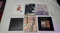 Top view of six Asian art and Tai Chi related books arranged on white surface