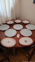 Top-down view of all 10 items showing the five plates, three bowls, and two platters arranged on a table.